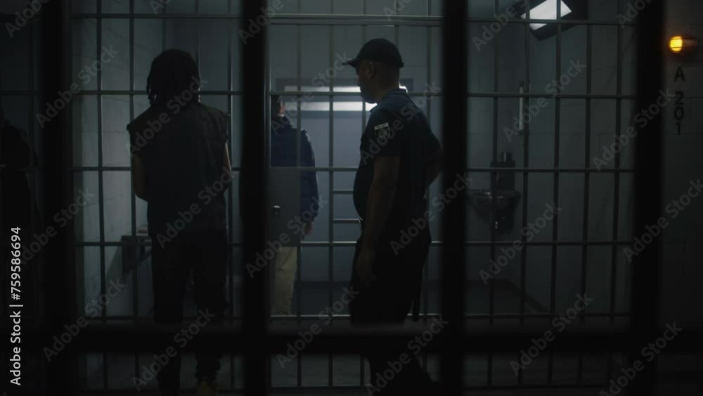 Warden brings new prisoner in jail cell and takes off his handcuffs ...