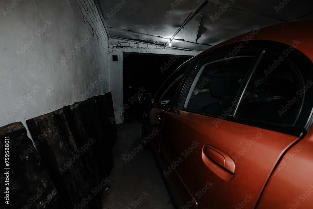 The car is parked in the garage of a house at night with the gate open Side view of a car parked in a home garage with the gate open to the street The car in the garage is protected from the weather.