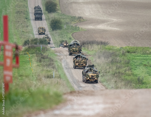 a convoy of British army Supacat Jackal 4x4 rapid assault, fire support and reconnaissance vehicle with camouflage, in action on a military exercise, Wilts UK photo