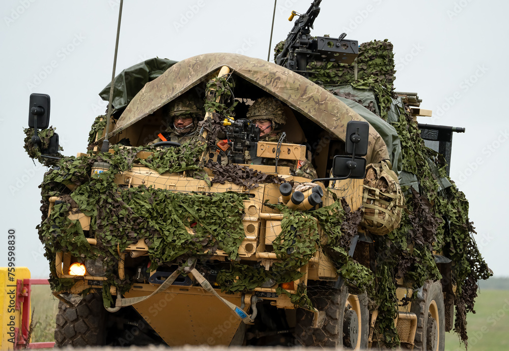 close-up of a British army Supacat Jackal 4x4 rapid assault, fire support and reconnaissance vehicle with camouflage, in action on a military exercise, Wilts UK