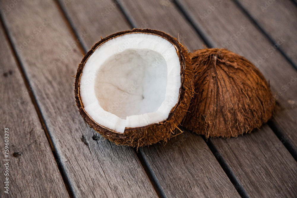 Coconut on wood cut in half with white flesh Coconut on wood cut in half with white flesh