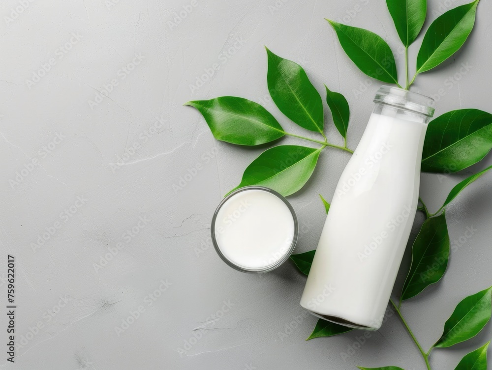 A bottle of milk sits delicately next to vibrant green leaves, creating a harmonious blend of natures elements
