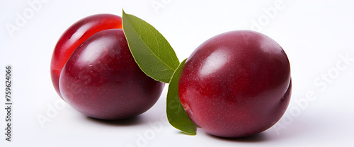 two ripe plums with leaves on a white background  Purple plums vegetarian. Berry leaves