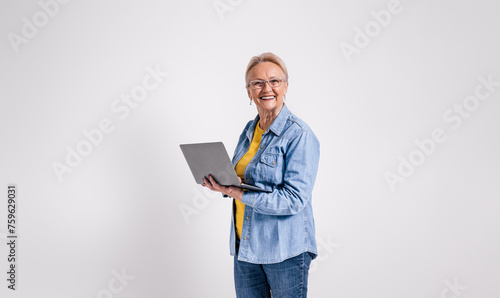 Portrait of cheerful senior businesswoman doing online research over laptop against white background