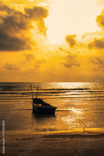 Fishing boats on the beach when the sun begins to set with a beautiful backdrop of sea and sand.