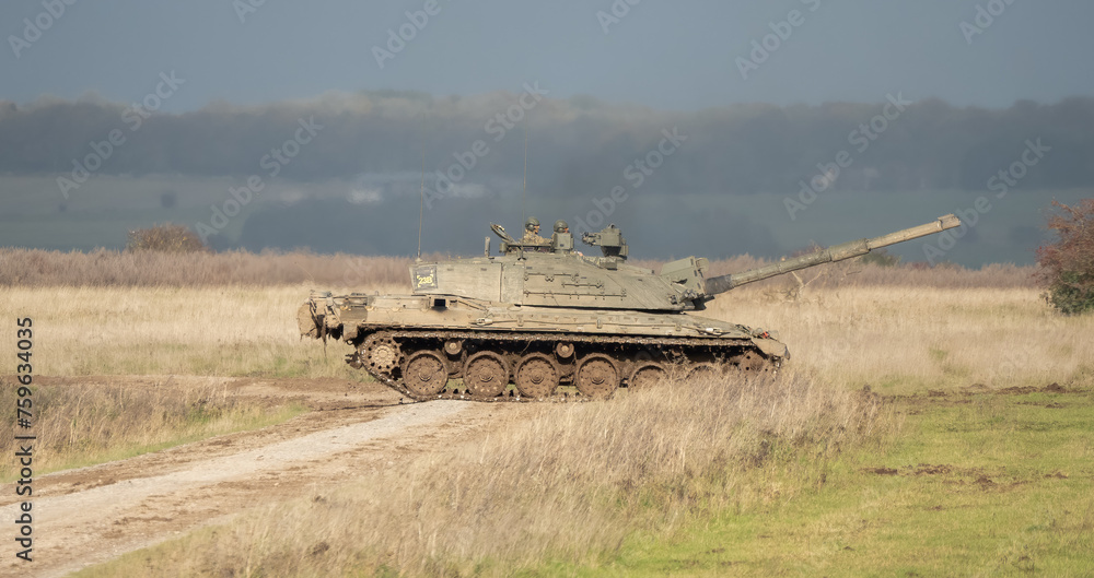 Fototapeta premium Commander and gunner directing a British army Challenger 2 II FV4034 main battle tank in action on a military exercise