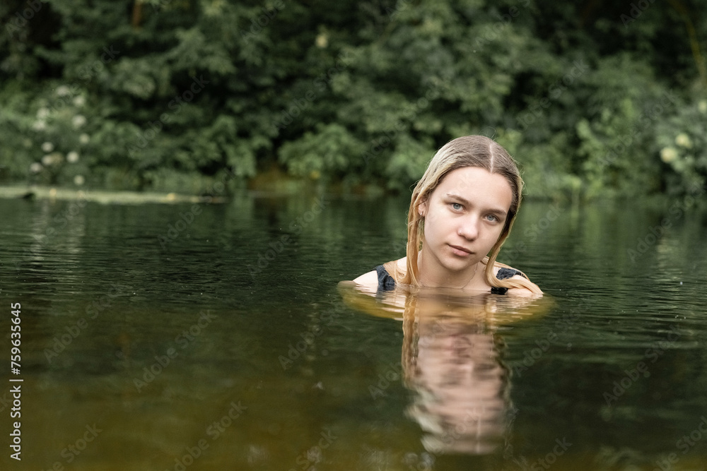 Portrait of a young beautiful blonde girl by the river. Portrait of a young beautiful blonde girl by the river.