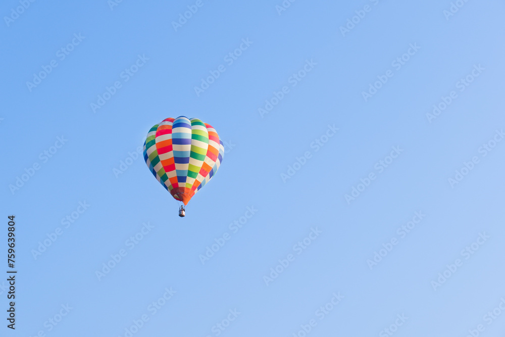 Fototapeta premium Hot air balloons landing in a mountain flight over field and forest,colorful Hot air balloons flying over the valley with blue sky,Tourism concept.