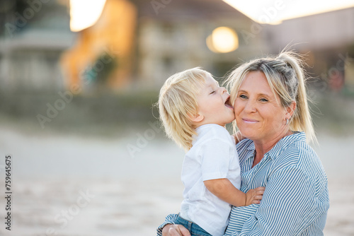 Mother and toddler son embracing on the sand of Gold Coast beach photo