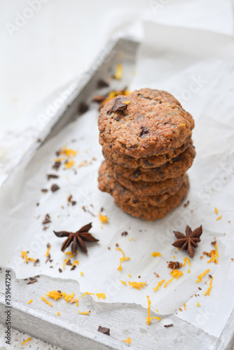 home made chocolate cookies with orange zest, chocolate chips and spices perfect for christmas on grey wooden background close up selective focus
