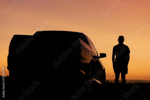 Sunset silhouette of man and car photo