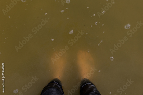 Standing in cloudy brown water photo