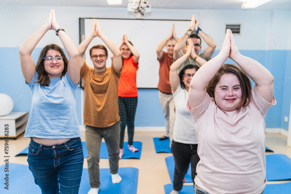 Fototapeta premium Participants with Down Syndrome lead a joyful yoga class, showcasing inclusivity.