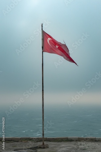 A Turkish national flag is displayed on a pole outdoors