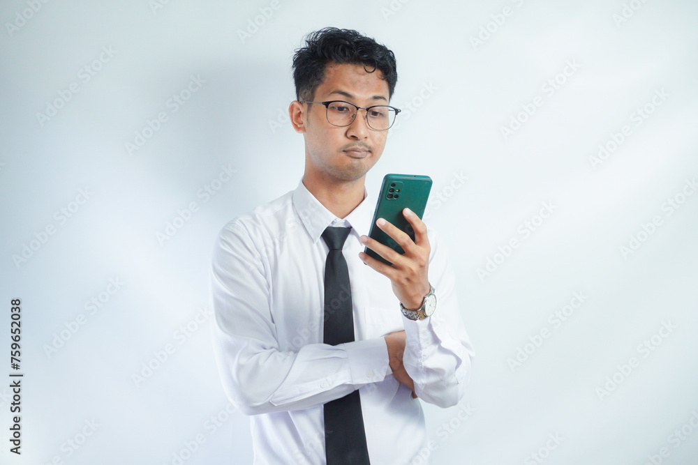 Young businessman in eyeglasses reading news over mobile phone against white background Young businessman in eyeglasses reading news over mobile phone against white background
