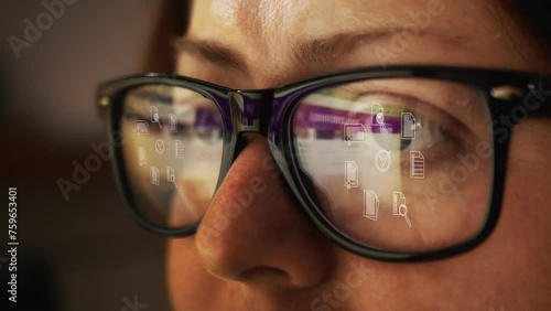 Cg footage with reflection in glasses on a female face searching for information on the Internet and rotating symbols of business documentation