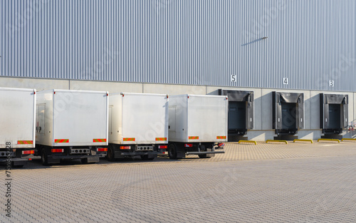 white trucks at loading ramps of a warehouse photo