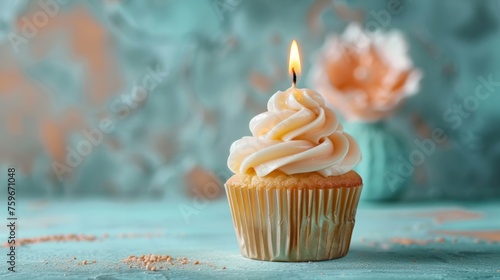 A top gold candle on a cupcake set against a soft pastel blue backdrop