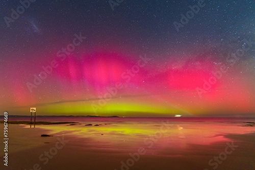 Aurora Australia illuminating the night sky and reflecting on a wet sandy beach photo