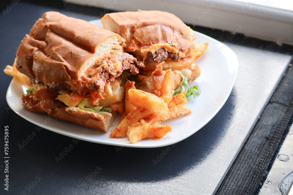 Masala steak Gatsby. South African fast food roll filled with chips, steak, braised onions and sauce. Masala steak Gatsby. South African fast food roll filled with chips, steak, braised onions and sauce.