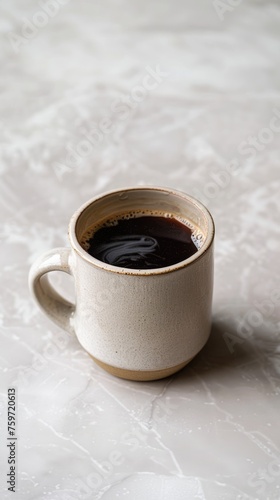 A minimalist ceramic mug filled with black coffee on a matte grey surface