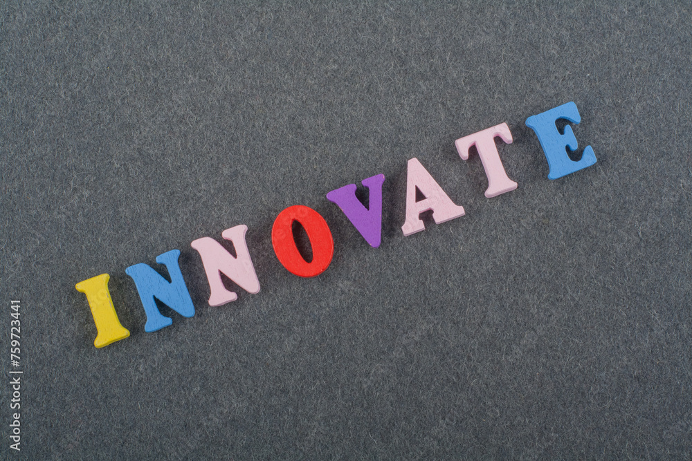 INNOVATE word on black board background composed from colorful abc alphabet block wooden letters, copy space for ad text. Learning english concept. INNOVATE word on black board background composed from colorful abc alphabet block wooden letters, copy space for ad text. Learning english concept.