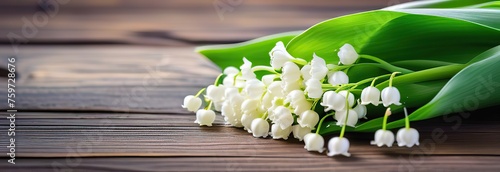 Fresh lily of the valley flowers on rustic wood, with a bright, blurred green background copy space wooden table top spring mood  photo