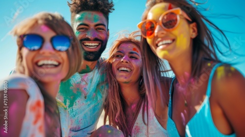 A joyous group of friends take a selfie, covered in color at a vibrant summer festival