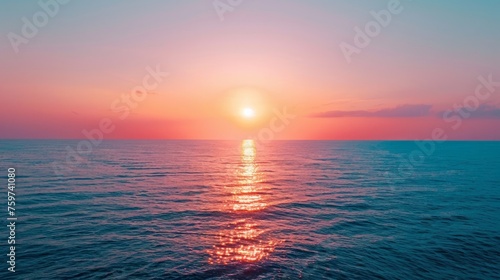 Sunset on the horizon, with the sun casting a warm glow over the sky and the sea