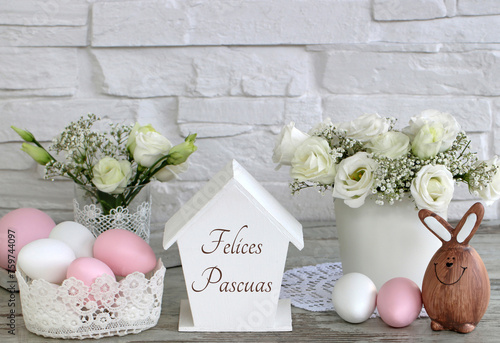 Tarjeta de felicitación Felices Pascuas: arreglo con conejitos de Pascua, flores y huevos de Pascua de colores. photo