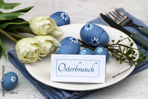 Gedeckter Ostertisch mit Osterdekoration und eine Tischkarte mit der Beschriftung Osterbrunch.	