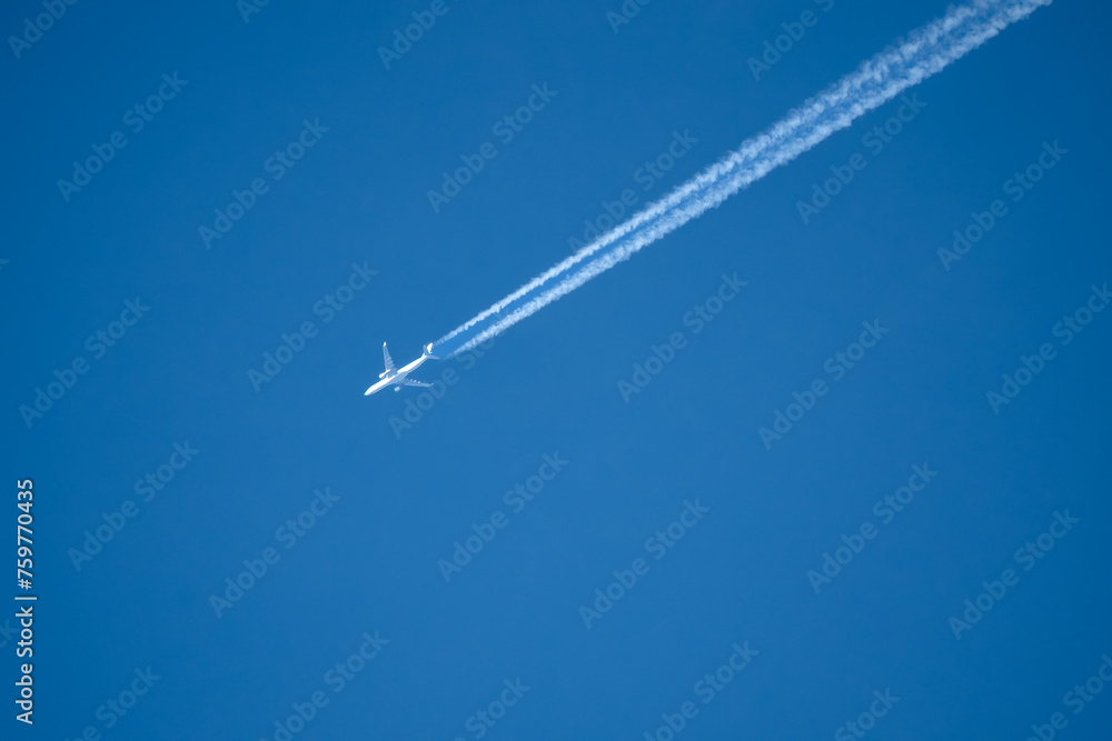 high altitude twin engine contrails (jet airplane vapour trails) across a deep blue clear sky high altitude twin engine contrails (jet airplane vapour trails) across a deep blue clear sky