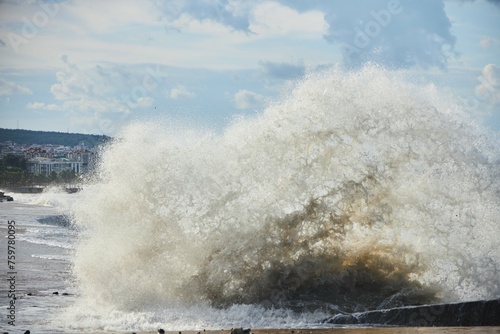 A storm and splashing waves on the seashore. The impact of water on the shore