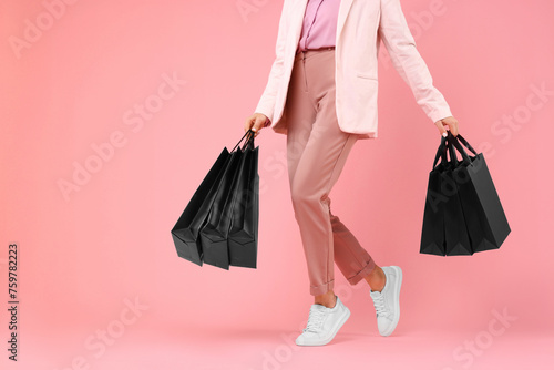 Woman with shopping bags on pink background, closeup