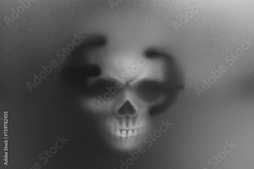 Silhouette of creepy ghost with skull behind cloth. Black and white effect photo