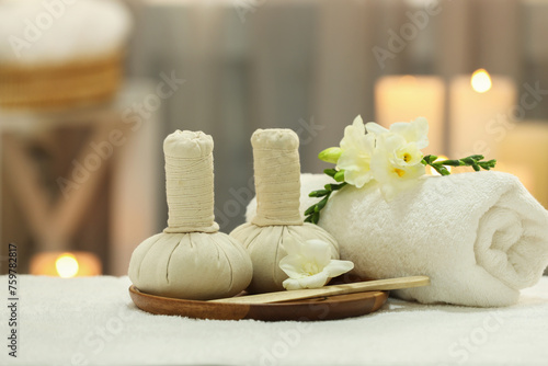 Beautiful composition with different spa products and flowers on white towel against blurred background