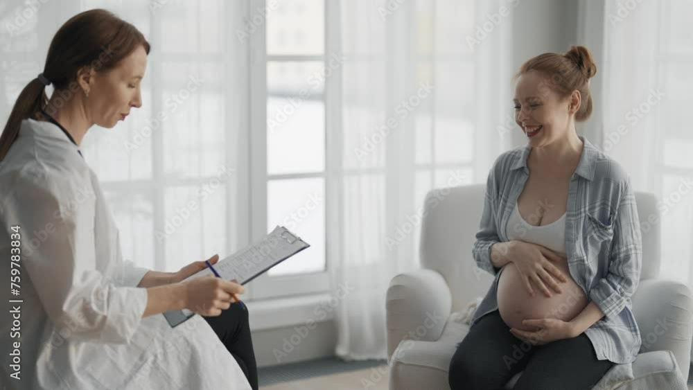 Pregnant woman consulting with a doctor. Smiling pregnant woman patient answers gynecologist questions at home, medical clinic. Doctor examine female pregnant belly check up. Gynecology concept. Pregnant woman consulting with a doctor. Smiling pregnant woman patient answers gynecologist questions at home, medical clinic. Doctor examine female pregnant belly check up. Gynecology concept.