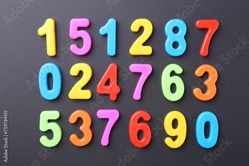 Colorful numbers on dark gray background  flat lay