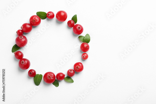 Frame made of fresh cranberries and green leaves on white background, flat lay. Space for text