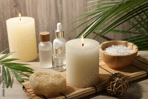 Composition with spa supplies and palm leaves on wooden table