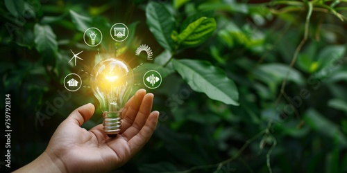 Hand holding a light bulb with icons of sustainable energy sources and green technology