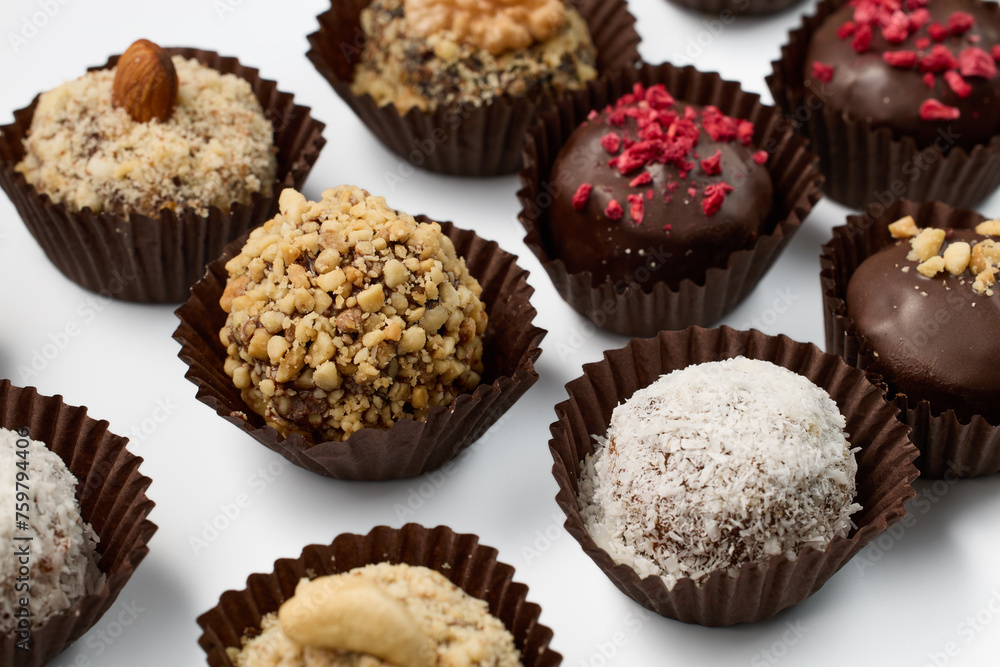 Set of round chocolate candies with nuts on a white background