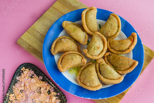 Gujia or Gujiya is a traditional Indian sweet or dessert made during Holi ,Diwali Festival.Resembles Spanish Empanada is deep fried or baked.Made from floor,milk solids,sugar,raisins,semolina.Closeup. photo