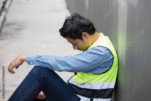 Asian male worker tired and thirst of water at construction site. Construction builder worker feel sick, have a headache. Health safe of work and safety first concept