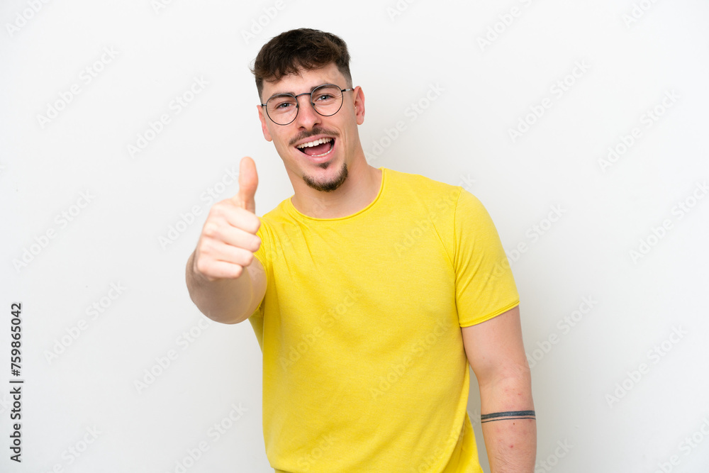 Young caucasian handsome man isolated on white background with thumbs up because something good has happened Young caucasian handsome man isolated on white background with thumbs up because something good has happened