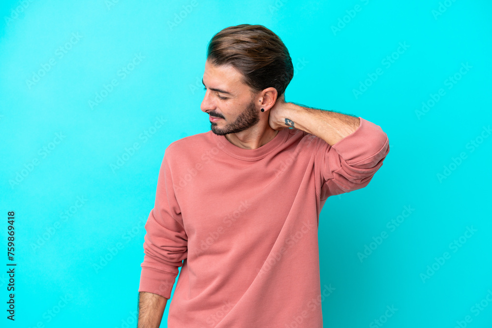 Young caucasian man isolated on blue background with neckache