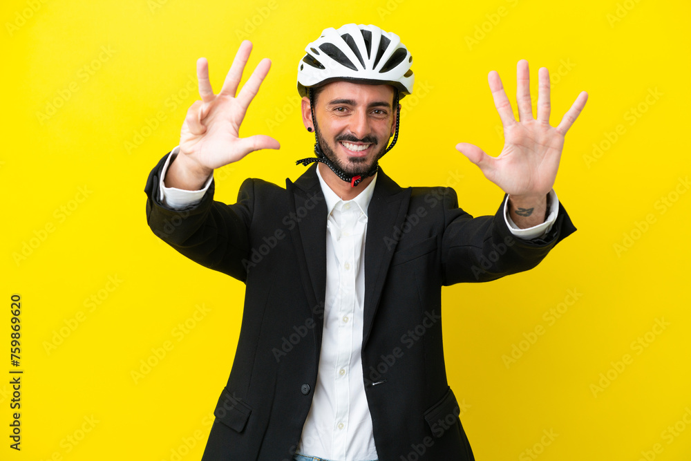 Business caucasian man with a bike helmet isolated on yellow background counting nine with fingers Business caucasian man with a bike helmet isolated on yellow background counting nine with fingers