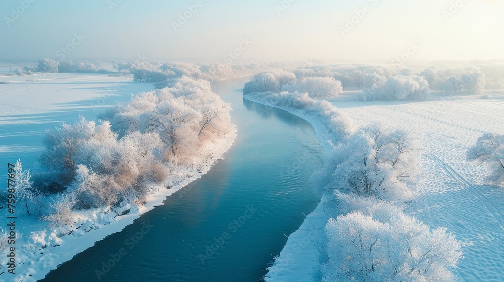A peaceful winter landscape with trees covered in frost along the banks of a gently flowing river on a clear day.
