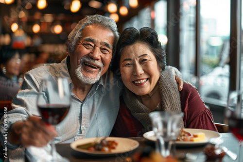 An elderly Asian couple shares a joyful moment over a glass of wine at a restaurant. Outdoor recreation. Leisure activity  interests. Happy moments