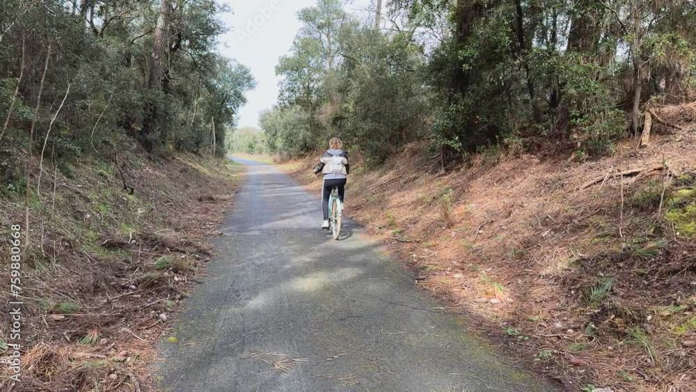 Piste cyclable bitumée avec femme faisant du vélo proche Piste cyclable bitumée avec femme faisant du vélo proche
